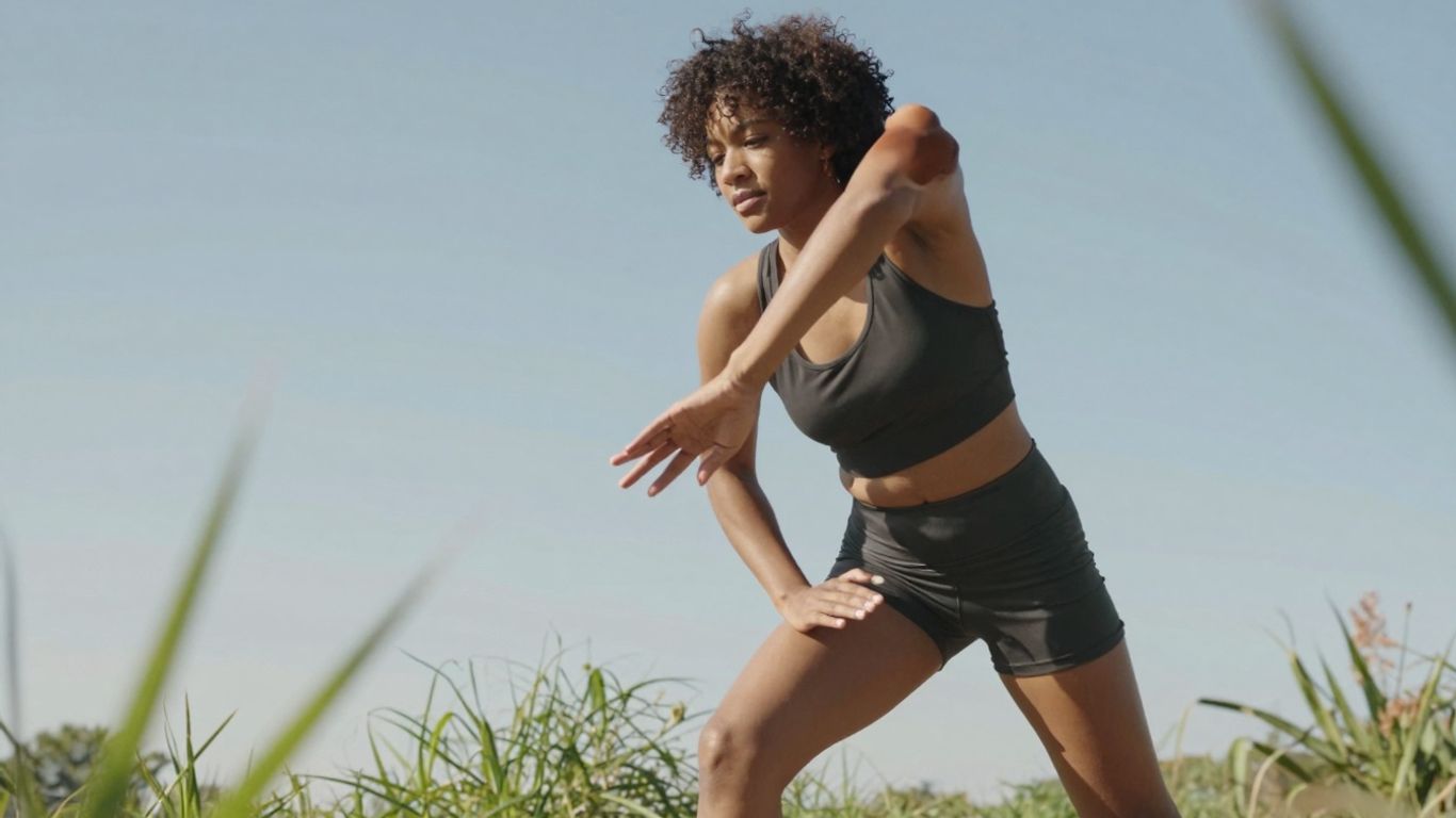 Person streckt sich energisch im Freien bei Sonnenschein.